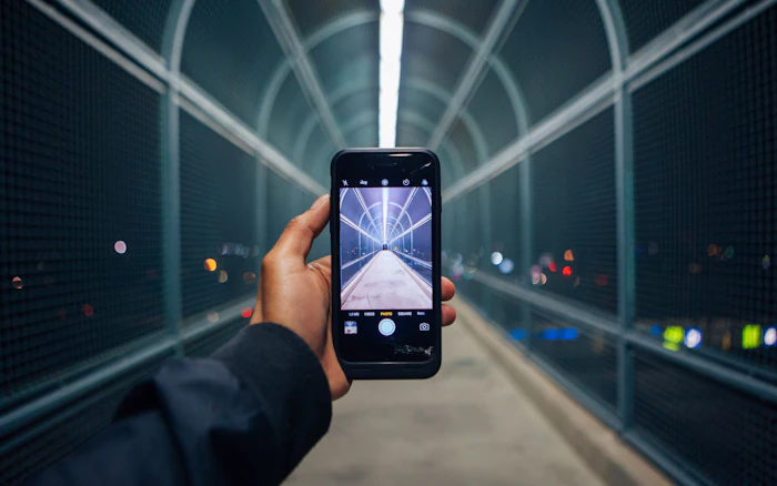 Phone photographing an illuminated city tunnel